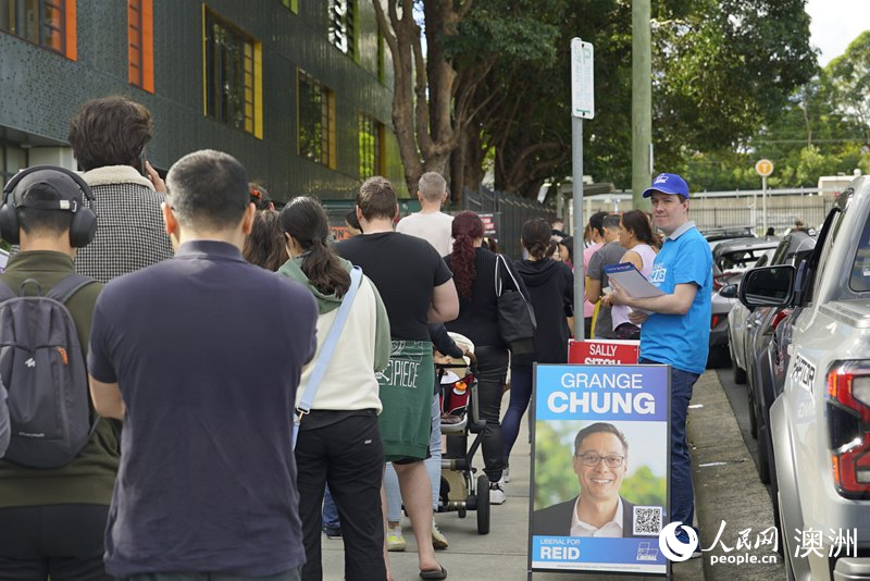 志愿者在投票站外向選民分發(fā)宣傳單（攝影 楊怡筠）