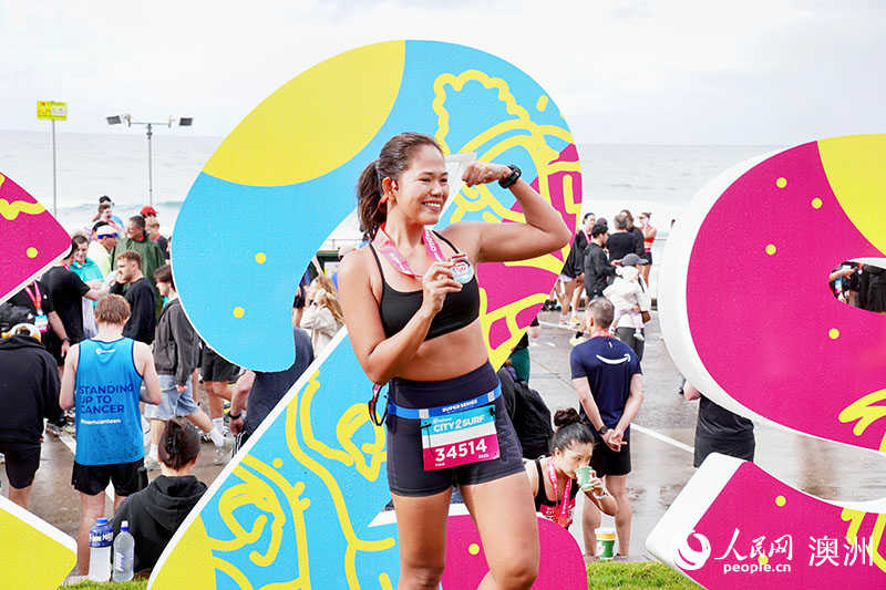 完賽跑者舉起獎(jiǎng)牌留影（攝影 陳芃蕾）